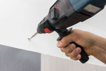 Drilling hole in bathroom wall for installing bathroom accessories. Selective focus.の写真素材