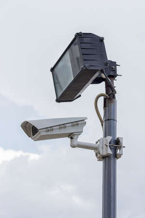 Security industries camera surveillance systems. Surveillance camera and lighting on plain pole.の写真素材