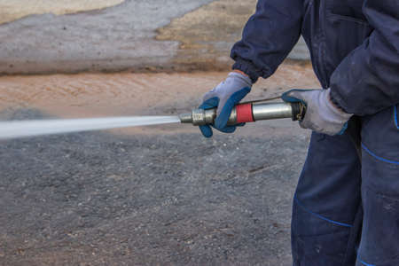 Using water hose to clean road by high pressure water.の写真素材