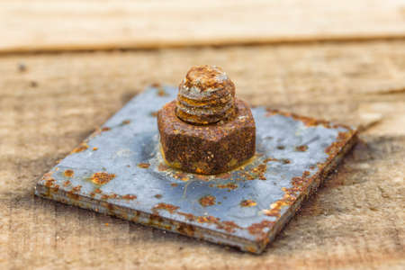 Old rust screw and nut on wooden background. Selective focus.の写真素材