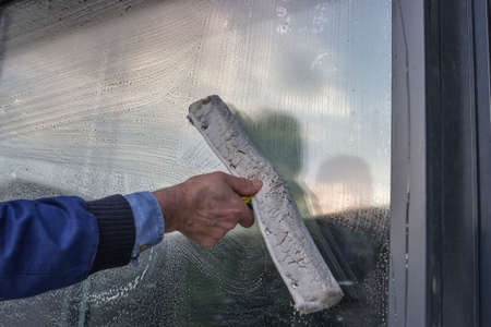 Hand cleaning window of a building, wash a windowの写真素材
