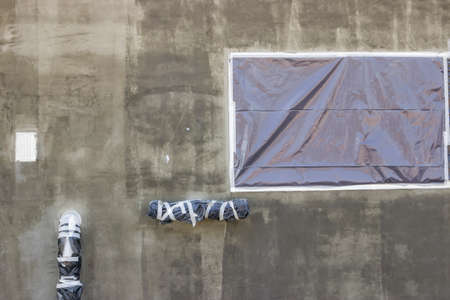 Exterior wall  with protected areas from application of all types of facade colors and plasters. Nylon protective foil before painting.の写真素材