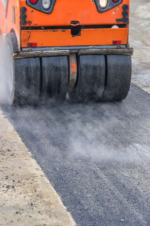 Detail of road roller during asphalt patching works. Selective focus.