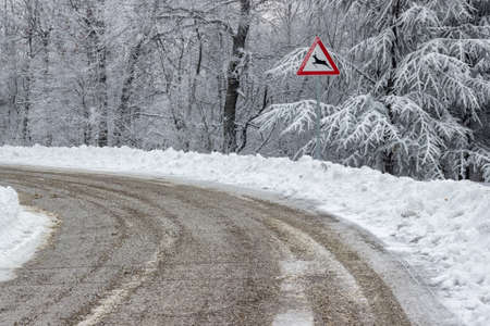 Traffic sign warns deer crossing. Road sign with a deer at winter.の写真素材