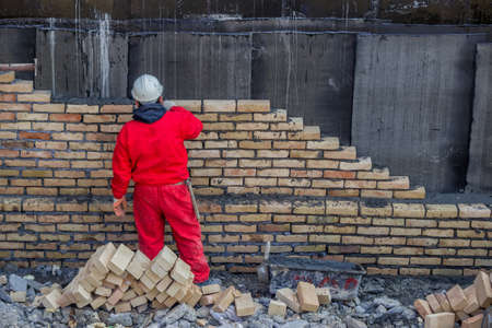 Mason bricklaying outdoors. Selective focus. At construction site.の写真素材