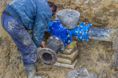Installing T junction for new commercial building water supplies. Installing water line, water main tap.の写真素材