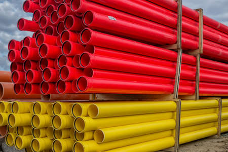 Stacks of various colored pvc water pipes at construction site
