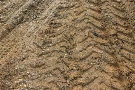 Tractor tyre track closeup on the muddy ground. Selective focus.の写真素材