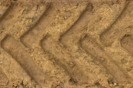 Tractor tyre track closeup on the muddy ground. Selective focus.の写真素材