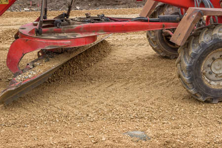 close up of motor grader working on gravel leveling for road construction. Selective focus.の写真素材