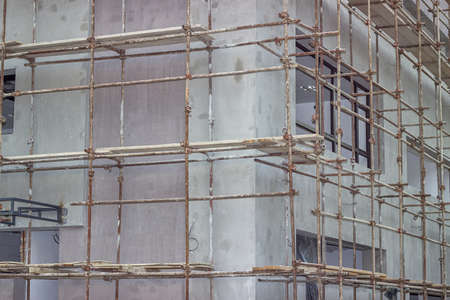 Building covered with scaffolding at construction site. Scaffolding on building.  Astract: construction industry.の写真素材