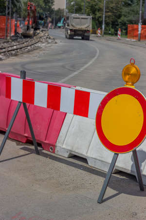 Construction barrier sign with yellow warning light, street reconstruction. Selective focus.の写真素材