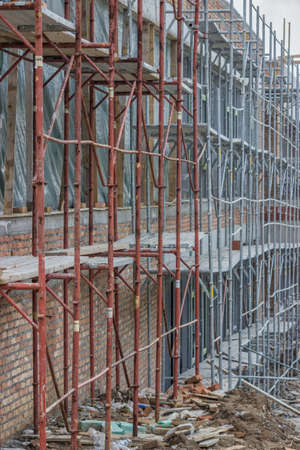 Scaffolding on building. Building covered in scaffolding at construction site. Astract: construction industry.の写真素材