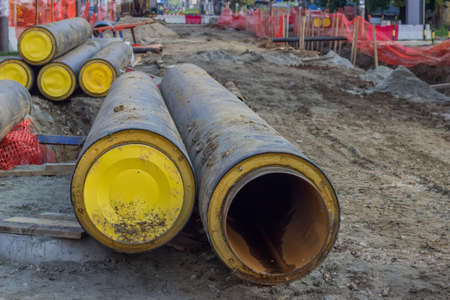 Stack of underground insulated pipes for heat system  at construction site. Selective focus.の写真素材