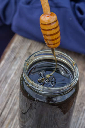 Spiral honey dipper and forest honey jar. Nectar of life. Selective Focus.の写真素材