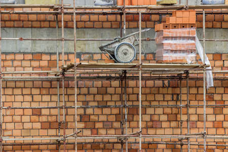Construction site with hollow clay block wall and scaffoldingの写真素材