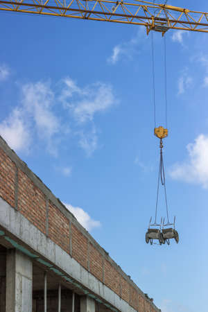 wheelbarrow lifting by construction crane on constructoin site.の写真素材