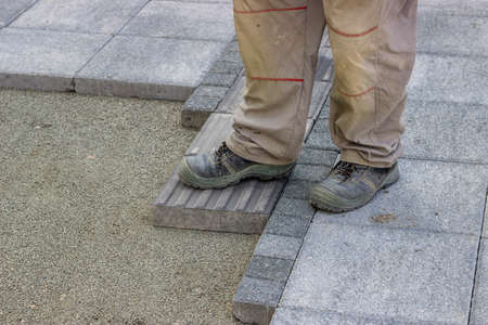Installing tactile paving, path for blind handicap on the sidewalk. Sidewalk pavement for vision impaired people. Shallow dof.の写真素材