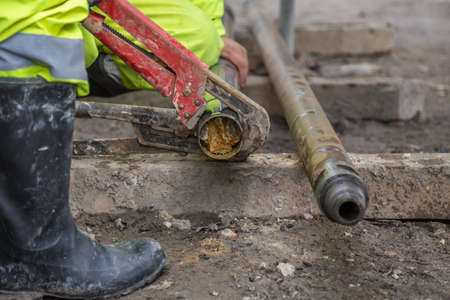Rig workers at site take out drill core sample for geological logging, analysis and testing. Taking soil core sample. Made with shallow dof.の写真素材