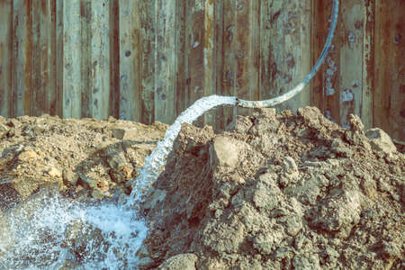 Detail of dewatering construction site. Pumping water out of the construction site. Construction dewatering and groundwater pumping. Made with selective focus and vintage style.の写真素材