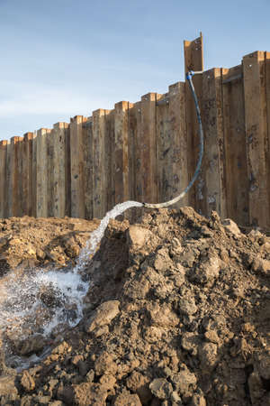 Dewatering construction site. Pumping water out of the construction site. Construction dewatering and groundwater pumping. Made with selective focus.の写真素材