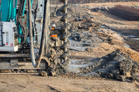 Drilling tractor installs concrete piles in the ground at construction site. Selective focus.の写真素材