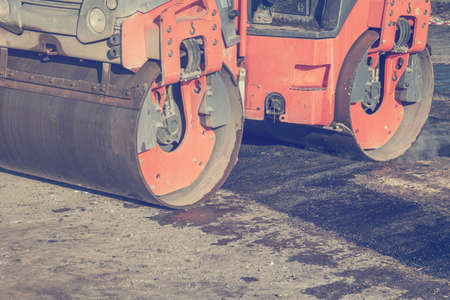 Mini asphalt roller during road patching, leveling. Made with vintage style.の写真素材