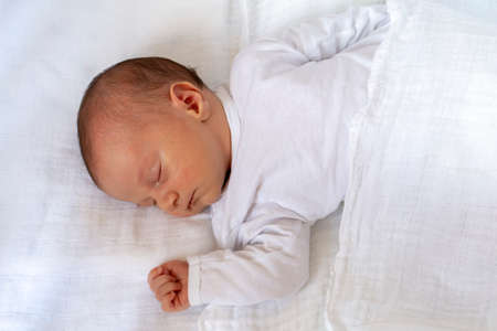 Newborn boy baby sleeping on his back. Little baby sleeping on white.の写真素材
