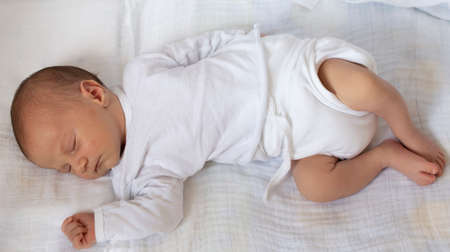 Newborn boy baby sleeping on his back. Little baby sleeping on white.の写真素材