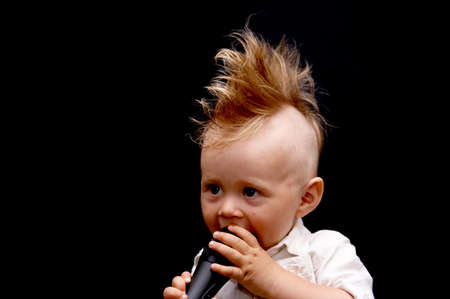 Portrait of the boy, singing in a microphone, with a ridiculous hairdressの写真素材