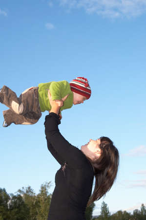 The mother lifts the son to the skyの写真素材
