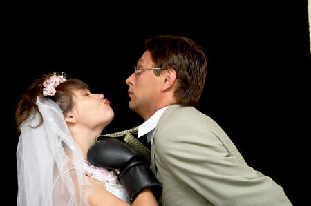 The bride kisses the groom on a black backgroundの写真素材