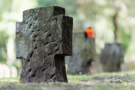 a row of stone crosses on a cemetery with blurred backgroundの写真素材