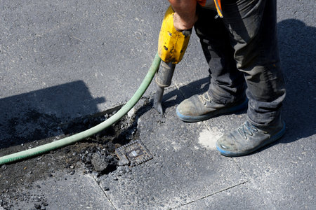road works on a gas pipeline, price up the asphalt of a road with a jackhammer to expose a gas connectionの写真素材