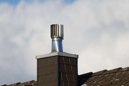 Stainless Steel Rotating Chimney Cowl on a chimney clad with slate tilesの写真素材