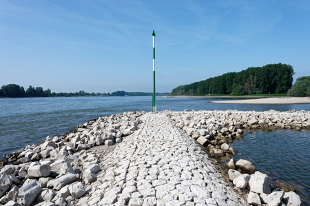 stone block pier with green and white signal mast on the rhine near cologneの写真素材