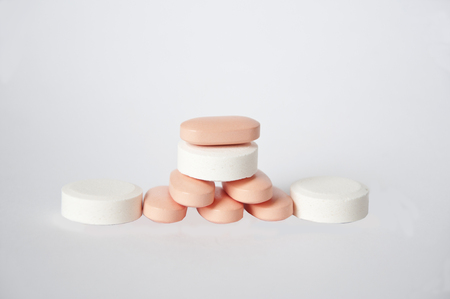 vitamins white and pink stacked in a pyramid on a white backgroundの写真素材