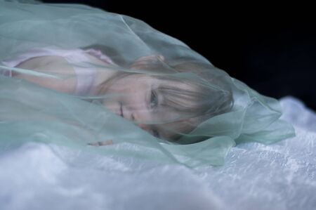 little lying girl covered transparent veilの写真素材