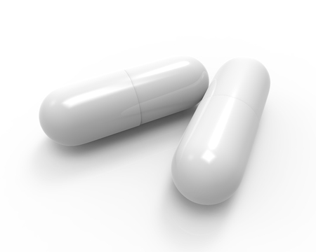 Close up of two white capsules isolated on white background.の写真素材