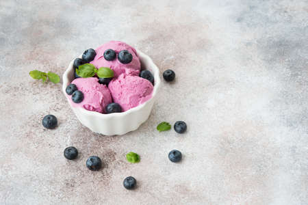 Homemade berry ice cream in a cup on a light concrete background.の写真素材