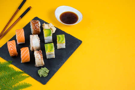 A set of sushi roll on yellow background with copy space. Traditional Japanese food. Horizontal orientation.の写真素材