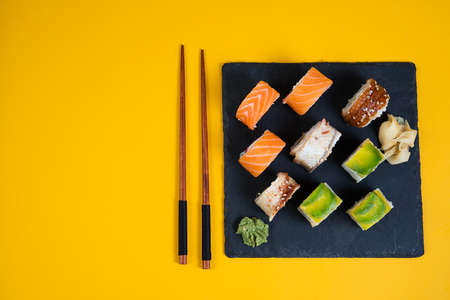 A set of sushi roll on yellow background with copy space. Top orientation. Traditional Japanese food. Horizontal orientation.の写真素材
