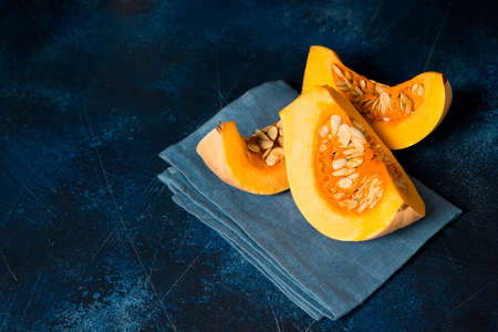 Sliced pieces of raw pumpkin on a blue backgroundの写真素材