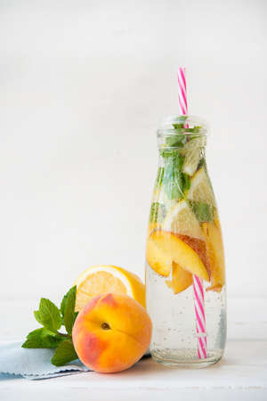 Homemade refreshing lemonade in a bottle with fresh fruit. Natural detox water.の写真素材
