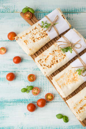 Traditional Mexican food burritos with beans and vegetables. Vegetarian rolls with red beans and...
