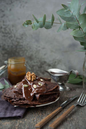 Chocolate thin pancakes with chocolate topping on a gray backgroundの写真素材