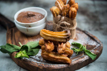 Traditional Spanish dessert donuts churros with chocolate and powdered sugar