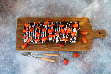 Delicious honey cake for tea decorated with sugar Fudge and fresh red strawberries.  Horizontal orientation. Top view.の写真素材