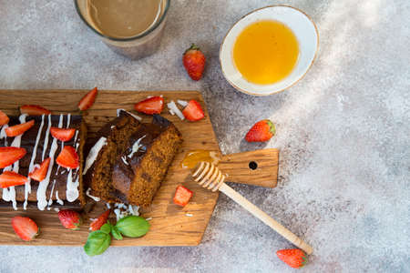 Delicious honey cake for tea decorated with sugar Fudge and fresh red strawberries.  Horizontal...