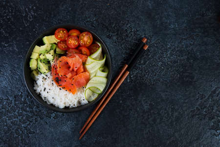 A popular Hawaiian dish, Poke in a plate of red fish, rice and vegetables. Poke plate on black...
